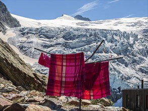 Colored bed linen dries in the sun, mountain hut Cabane de Moiry, located close to the retreating