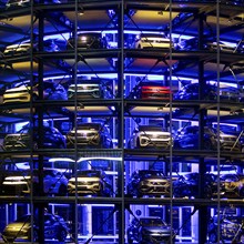 An illuminated car tower with new cars for delivery in the evening, detail, Autostadt, Volkswagen