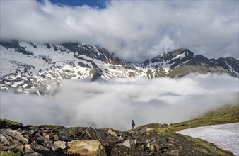 Mountaineer in front of mountain landscape with high fog in the valley, summit Hochfeiler and