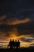 People marvelling at Montafon mountains with dramatic cloudy sky at sunset, Tschagguns, Rätikon,