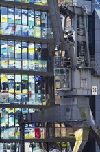 Old crane in front of the glass façade of an office building, reflecting the Colorium high-rise,