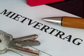 Symbolic image of rental agreement: close-up of a rental agreement and front door key