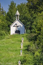 Close-up of the chapel on a wooded hill with graves. Quiet summer atmosphere, Gundringen, Nagold,