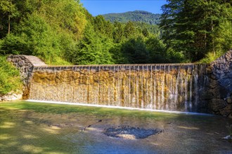 A small waterfall in a wooded area in sunny weather, Bad Feilnbach, Jenbach