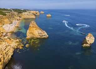 Aerial view of the rocky coast of Algarve, Portugal, with beaches and boats on the blue sea, beach,