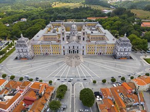 Historical palace captured in impressive symmetry as an aerial view, surrounded by green