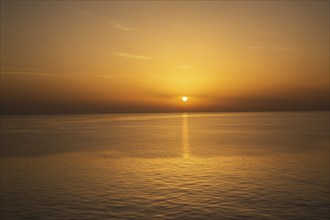 Setting golden sun over Adriatic sea taken from the top deck of a cruise ship in late summer, near