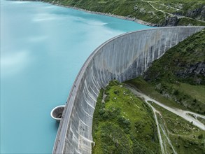 Dam of the Moiry lake, Lac de Moiry, turquoise glacial water, water overflow, tourists, aerial