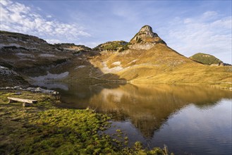 Lake Augstsee and the Atterkogel mountain on the Loser. A bench on the left. Autumn, good weather,