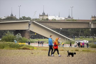 Passers-by look at the partially collapsed Carola Bridge from the Königsufer in Dresden, 11/09/2024