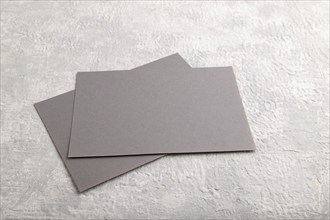 Gray paper business card, mockup on gray concrete background. Blank, flat lay, top view, still