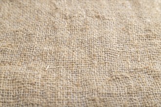 Fragment of smooth brown linen tissue. Side view, natural textile background and texture