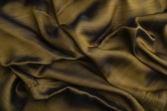 Fragment of yellow and green tissue. Side view, synthetic textile background and texture. wave