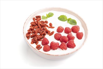 Yogurt with raspberry and goji berries in ceramic bowl isolated on white background. Side view,