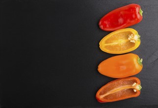 Yellow, red, orange sweet peppers on a black slate background. top view, copy space, flat lay,