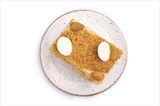 Honey cake with milk cream, caramel, almonds isolated on a white background. Top view, flat lay,