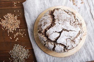 Yeast free homemade bread with whole rye and wheat grains on rustic wooden background. Top view