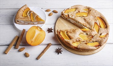 Sweet persimmon pie on white wooden background. close up