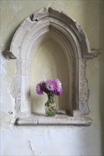 Church of Saints Andrew and Eustachius, Hoo, Suffolk, England, UK dahlia flowers in vase in stone