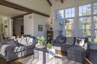 Dark grey upholstered ektorp model sofas in living room with rug and stained oak wood floorboards