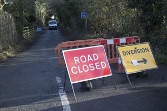 Road closed signs after storm damage tree fallen blocking road, Hollesley, Suffolk, England, UK