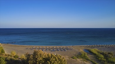 Beach, wetland, umbrellas, sun loungers, green-blue sea, blue cloudless sky, Frangokastello,