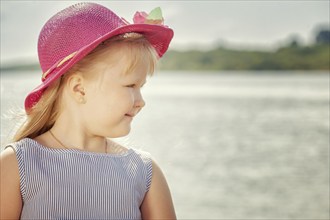 Portrait of beautiful little blond girl in pink hat