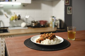 Homemade spicy chicken stew with vegetables and rice on a kitchen table