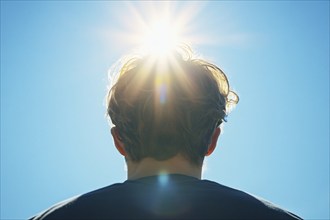 Back view of man with sun in blue sky. Generative Ai, AI generated