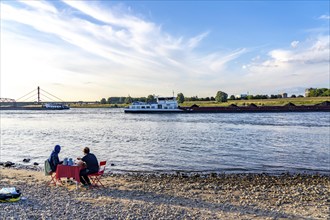 The Rhine at Duisburg-Baerl, man and woman having a picnic on the Rhine beach, at low tide, on the