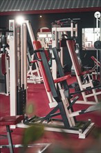 Fitness studio with various modern training machines in a red and steel environment, Historic