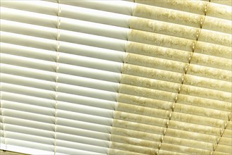 Residential window shades showing the before and after of a good cleaning, one side clean and one