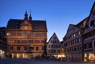 Historic town hall, illuminated, Neptune fountain, market square, in summer, people relaxing in