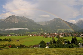 View over Oberstdorf with rainbow on Rubihorn and Geißalphorn, Schattenberg on the right,