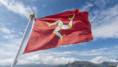 The flag of the Isle of Man, Great Britain, flutters in the wind