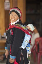 Vietnamese woman, 43 years old, in traditional traditional costume of the Dao minority, carrying