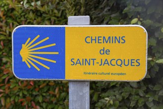 A signpost for the Chemins de Saint-Jacques, yellow-blue with scallop shell symbol, Way of St