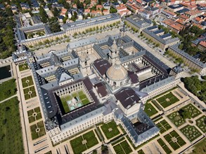 Large historic monastery with several courtyards, surrounded by parks and a town, aerial view, Real