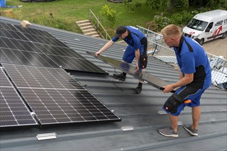 Installation of solar modules on the roof of a barn on a farm, over 240 photovoltaic modules are