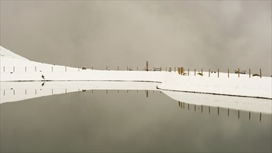 After snowfall in May: Riezler Alpsee, an artificial lake, snow pond, feeds the snow cannons that