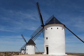 White windmills against a bright blue sky in a rural landscape on a sunny day, Alcazar de San Juan,