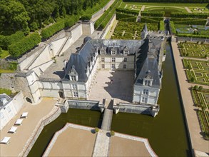 Aerial view of a castle with moat and formal gardens surrounded by high stone walls, aerial view,