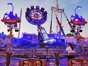 People on the illuminated carousel Mr Gravity in the evening, Cranger Kirmes, Herne, Ruhr area,