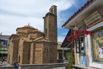 Byzantine church next to a snack shop with people walking around, Church of the Apostles, Agii