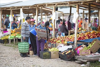 Peruvian family buys fruit at the Indio market in Chinchero, Cusco region, Peru, South America