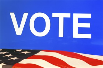 USA flag in front of a blue screen with the inscription VOTE