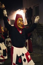 Fool figure with torch in hand celebrates carnival at night, carnival, Schellbronn night