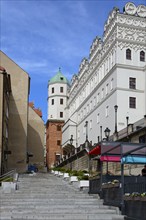 View of a historic building facade with a staircase under a blue sky with clouds, Castle of the