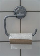 Last sheet of toilet paper on a toilet roll