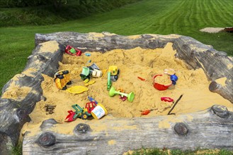 Sandpit, on a children's playground, sandpit with various plastic toys, excavator, shovels, moulds